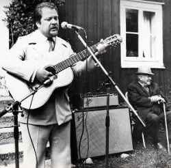 Trubaduren Rolf Nilsson fr�n Skattl�sberg spelar gitarr och sjunger vid H�gan - klicka f�r att f�rstora