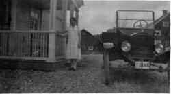 Kvinna framf�r huvudbyggnaden till Binninge g�rd med en bil T-Ford med registreringsskylt T2148. - klicka f�r att f�rstora