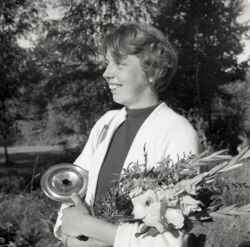 En kvinna med blommor och en kastrull i samband med JUFs distriktsm�sterskap i orientering i �stern�rke - klicka f�r att f�rstora