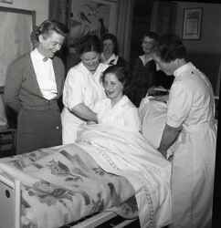 En grupp kvinnor runt en sjuksng under en sjukvrdskurs fr Rda korset - klicka fr att frstora