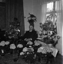 Man omgiven av blommor. Bilden �r troligen tagen i samband med en f�delsedag. - klicka f�r att f�rstora
