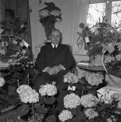 Man omgiven av blommor. Bilden �r troligen tagen i samband med en f�delsedag. - klicka f�r att f�rstora
