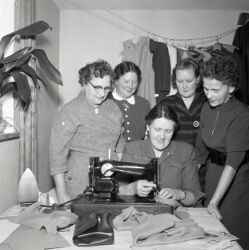 En grupp kvinnor kring en symaskin p systuga i Mullhyttan - klicka fr att frstora
