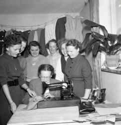 En grupp kvinnor kring en symaskin p systuga i Mullhyttan - klicka fr att frstora