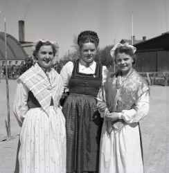 Tre kvinnor i folkdr�kt under en trolig utst�llning vid Idrottshuset i �rebro - klicka f�r att f�rstora