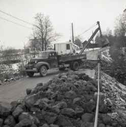 Lastbil och gr�vmaskin vid ombyggnaden av bron vid Kvistbro kyrka. Bilden �r tagen mot Kvistbro kyrka med klockarbostaden till v�nster. - klicka f�r att f�rstora