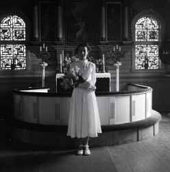 Flicka med blommor i koret i Kvistbro kyrka efter konfirmationen psken 1954 - klicka fr att frstora