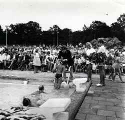 Simmande barn f�r en krans i h�ret av en man under invigningen av Sannabadet �r 1970 - klicka f�r att f�rstora